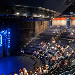 The auditorium in West Yorkshire Playhouse. Some of the seats are filled with people
